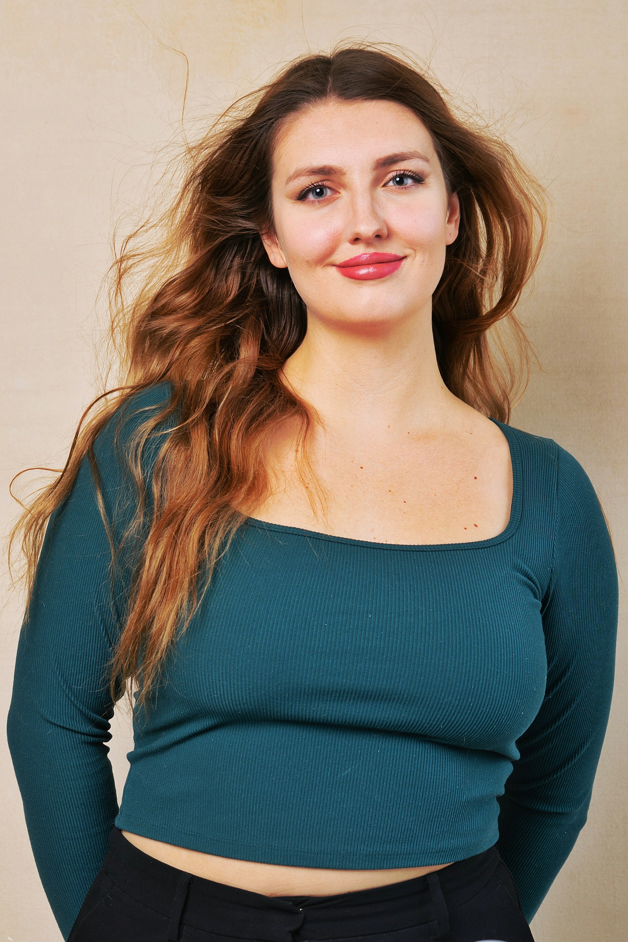 Smiling woman with long, wavy auburn hair
