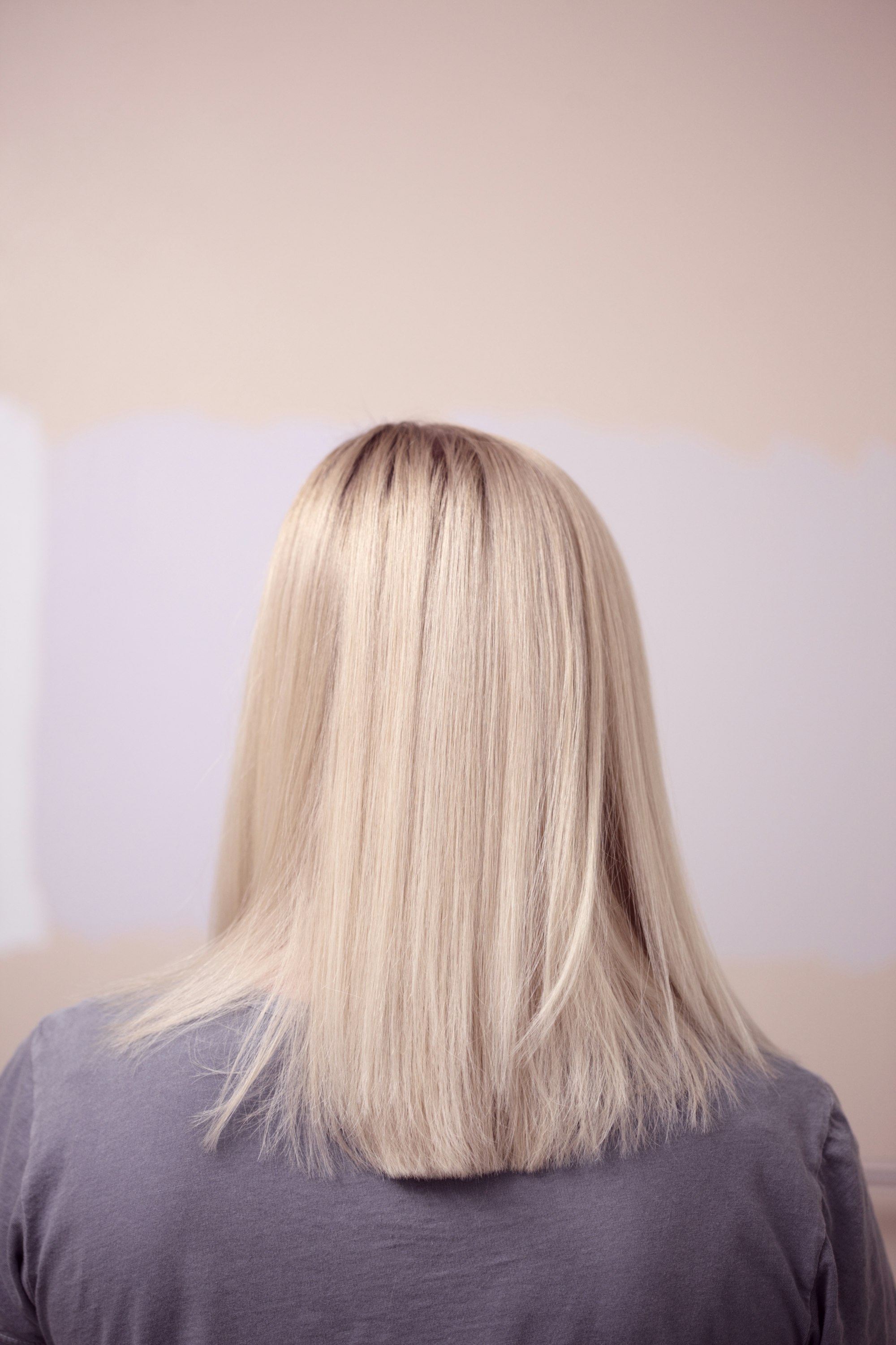 Woman seen from behind with a sleek, shoulder-length blonde bob