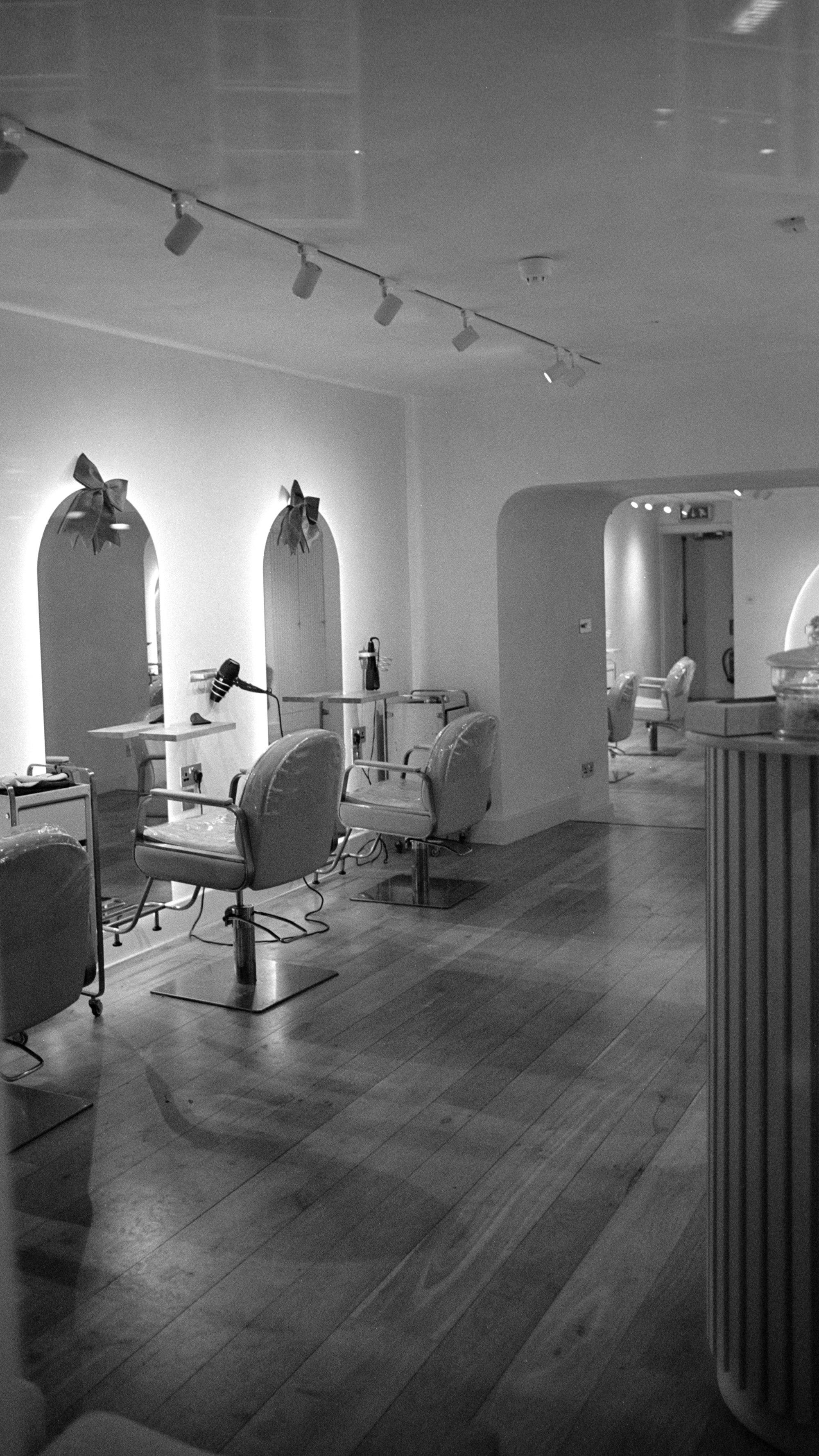 A modern salon interior with stylish chairs and large mirrors