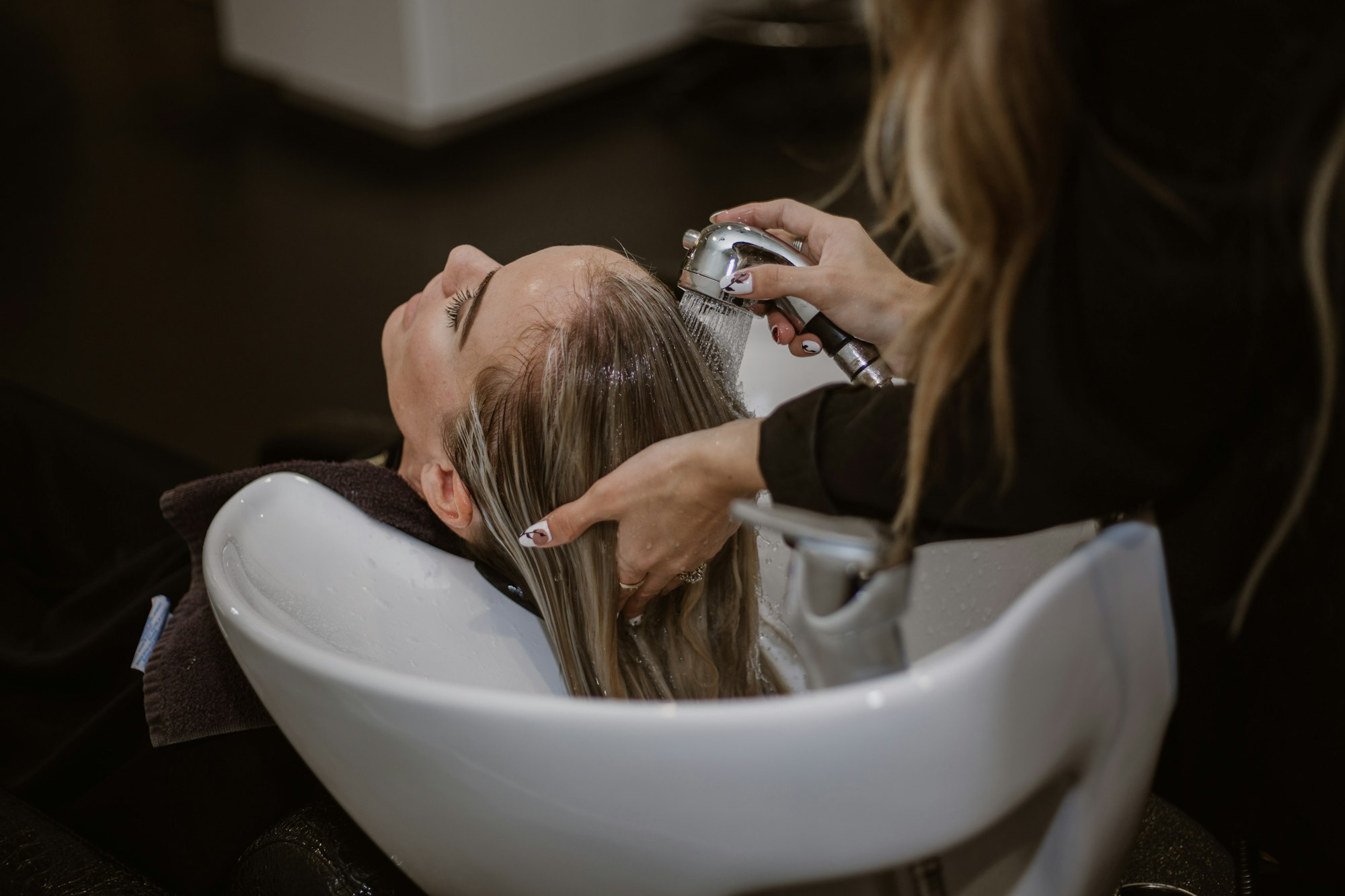 A client having her hair washed at a salon basin